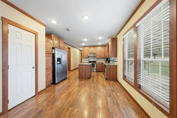 a kitchen with stainless steel appliances granite countertop a stove a sink and a microwave