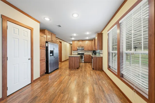 a kitchen with stainless steel appliances granite countertop a stove a sink and a microwave