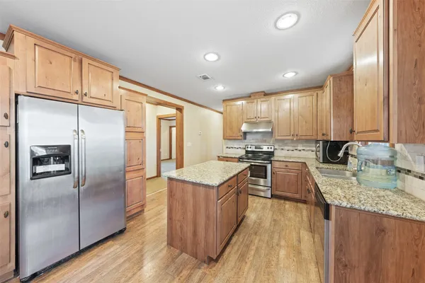 a kitchen with stainless steel appliances granite countertop a sink stove and cabinets