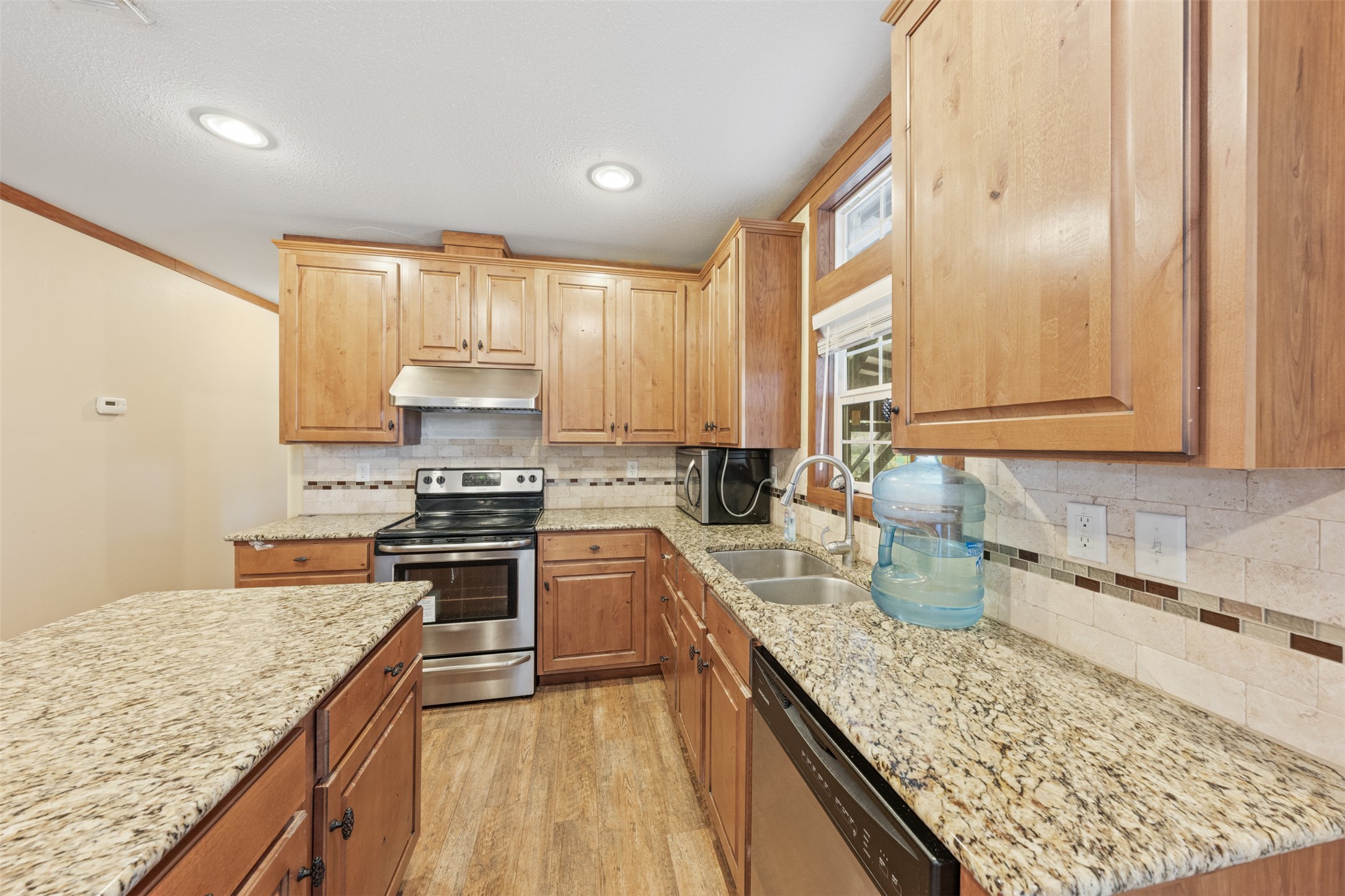 4636 Highway 71 Columbus, TX 78934 - Photo 38 of 50 a kitchen with stainless steel appliances granite countertop a sink stove and cabinets