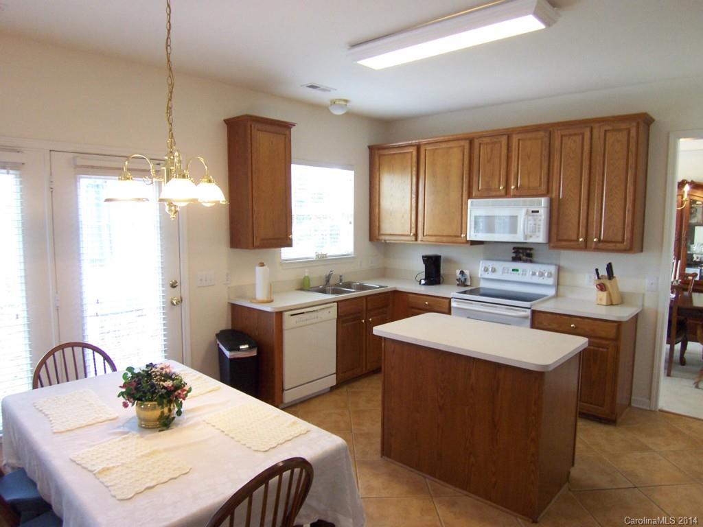 415 Lafinca Court Fort Mill, SC 29708 - Photo 7 of 17 a kitchen with stainless steel appliances granite countertop a sink a stove a kitchen island with a dining table and chairs