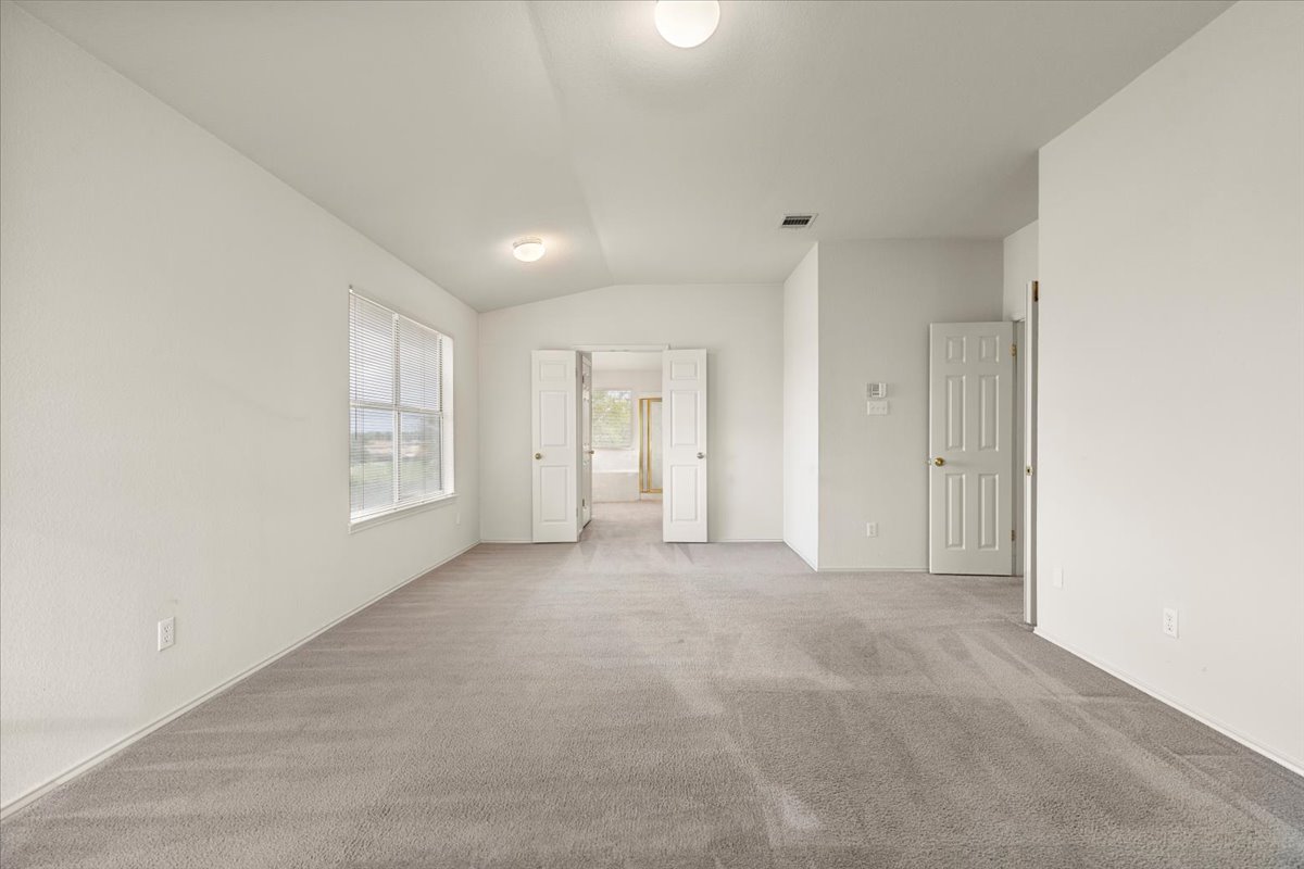 3929 Katzman Drive Austin, TX 78728 - Photo 15 of 29 Carpeted spare room featuring lofted ceiling and baseboards