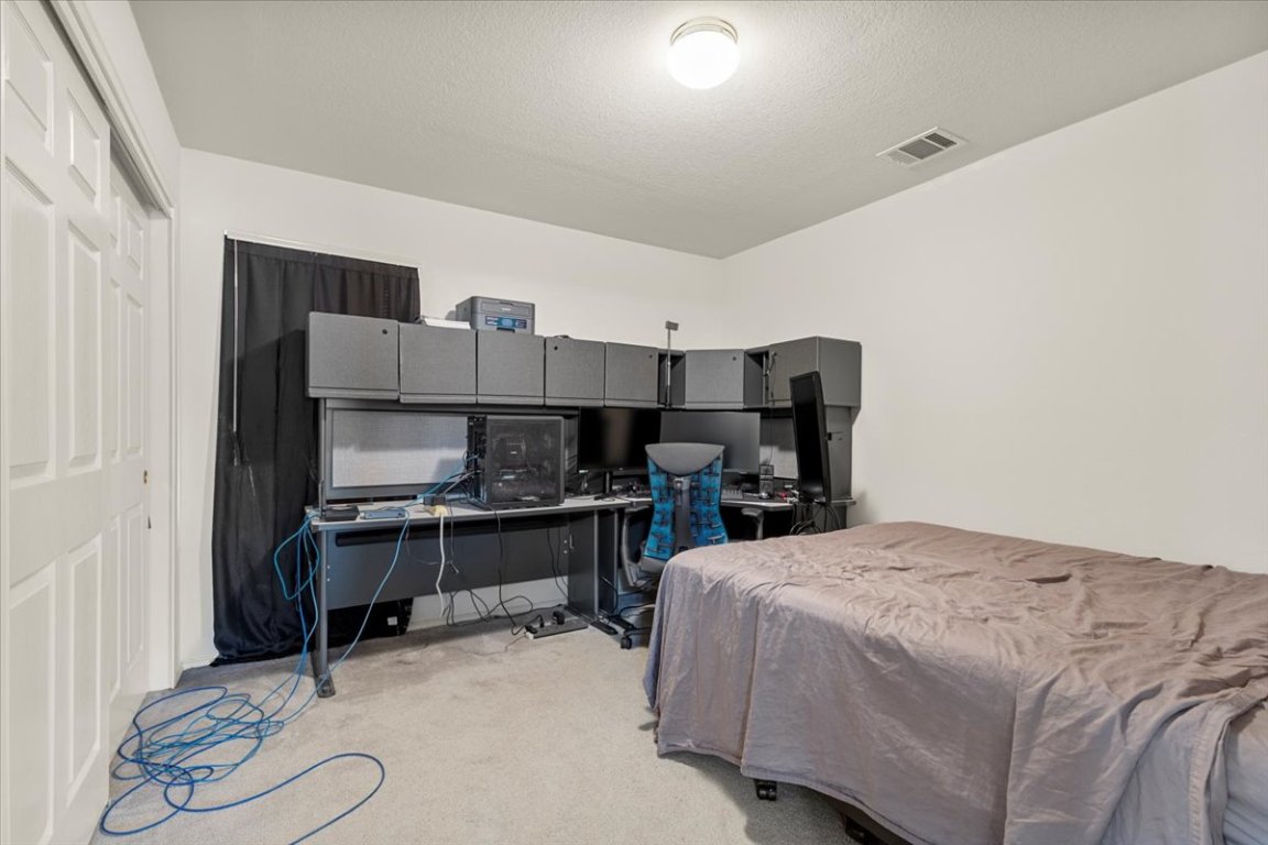 3929 Katzman Drive Austin, TX 78728 - Photo 22 of 29 a bedroom with a bed and a desk