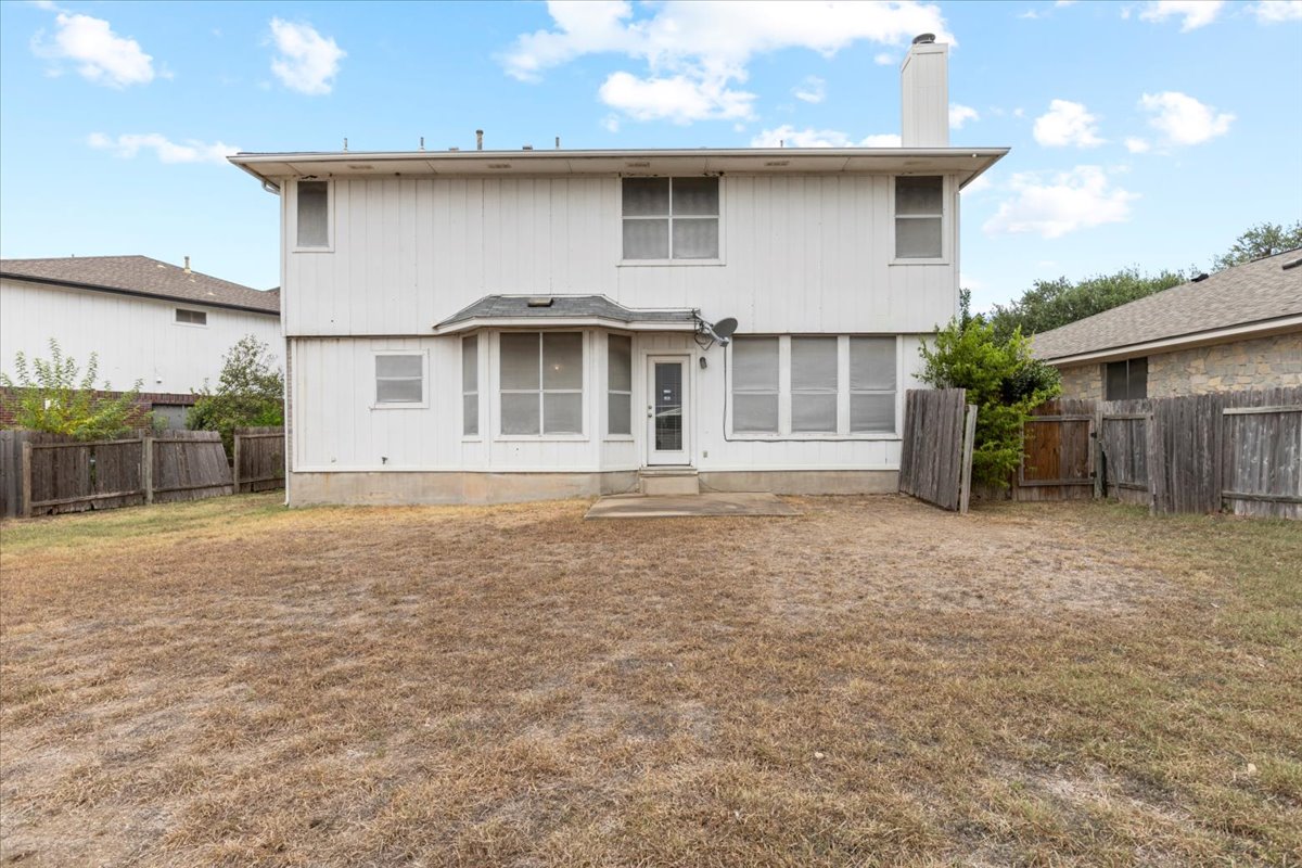 3929 Katzman Drive Austin, TX 78728 - Photo 27 of 29 Back of house featuring a fenced backyard and a chimney