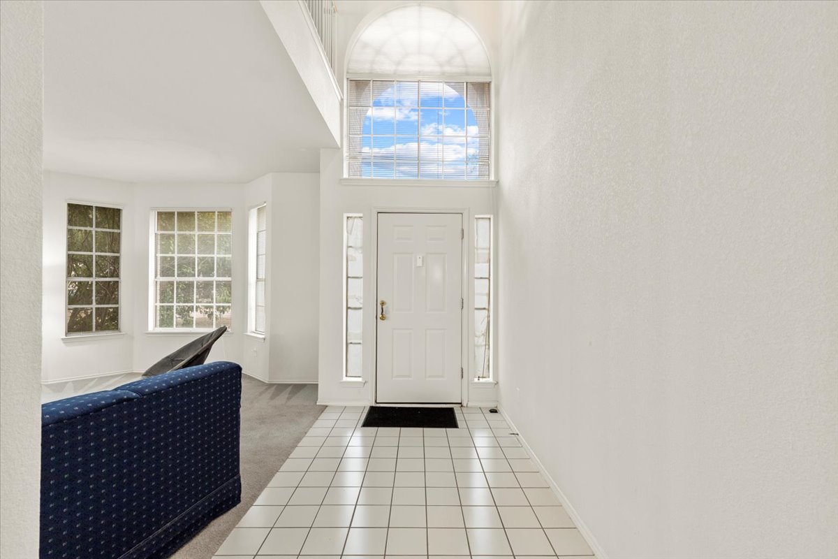 3929 Katzman Drive Austin, TX 78728 - Photo 4 of 29 Foyer entrance featuring light tile patterned floors, light carpet, and a high ceiling