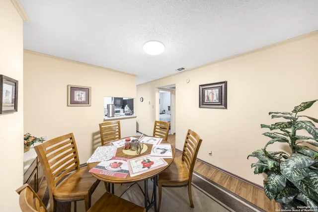 a dining room with furniture and a potted plant