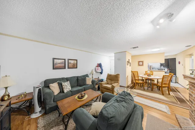 a living room with furniture and a dining table with kitchen view