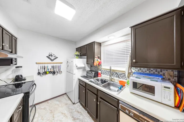 a kitchen with stainless steel appliances a stove a sink and a refrigerator