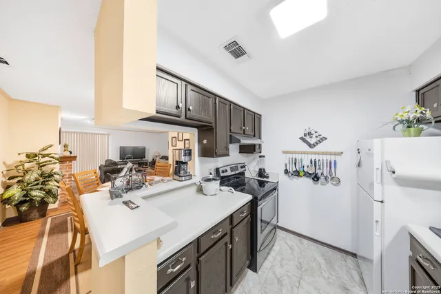 a view of a kitchen with a sink dishwasher stove and refrigerator