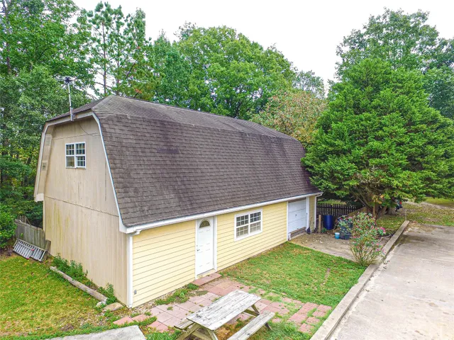a aerial view of a house next to a yard with plants and trees