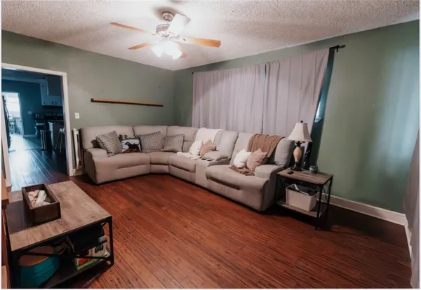 a living room with furniture and a wooden floor