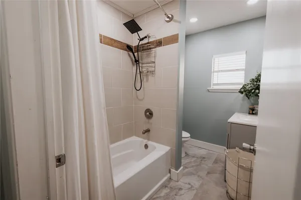a bathroom with a tub a sink and glass door