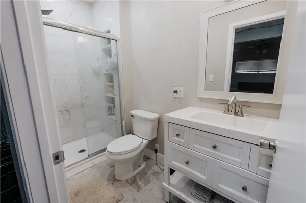 a bathroom with a sink a toilet and shower