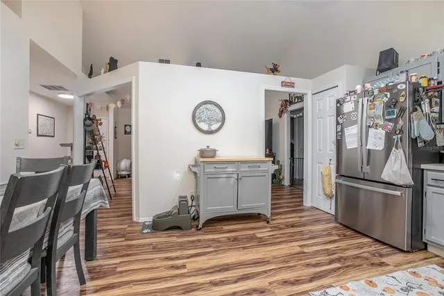 a view of a kitchen with refrigerator and wooden floor