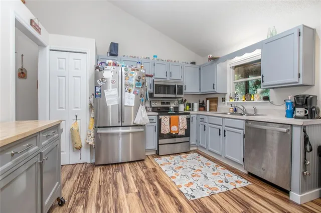 a kitchen with stainless steel appliances granite countertop a refrigerator sink and stove