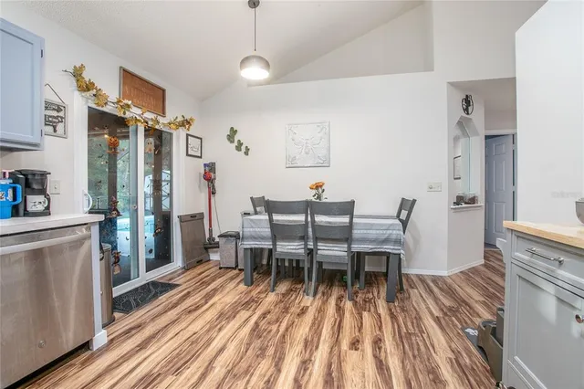 a dining room with furniture a chandelier and wooden floor