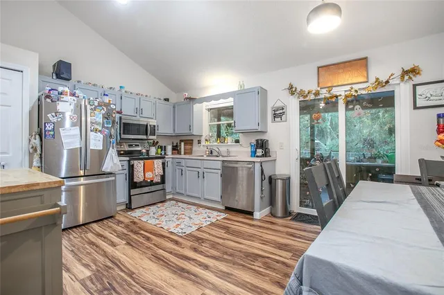 a kitchen with stainless steel appliances a refrigerator and a wooden floor