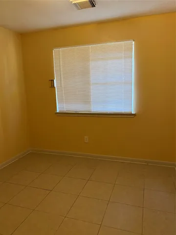a view of a small space with wooden floor and a window