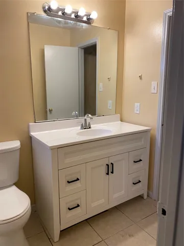 a bathroom with a sink toilet and mirror