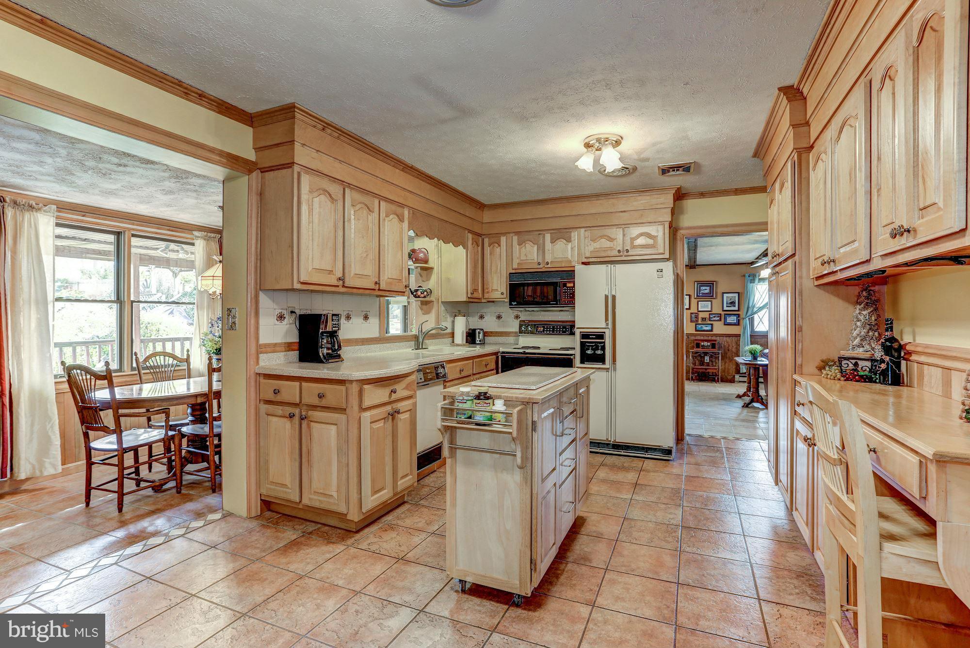 2 Nichols Road Luray, VA 22835 - Photo 4 of 30 a kitchen with stainless steel appliances granite countertop a stove top oven a sink a dining table and chairs with wooden floor