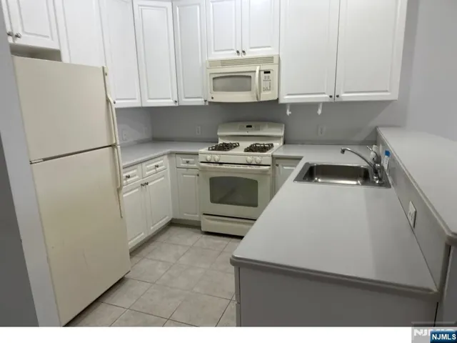 a kitchen with a refrigerator sink and cabinets