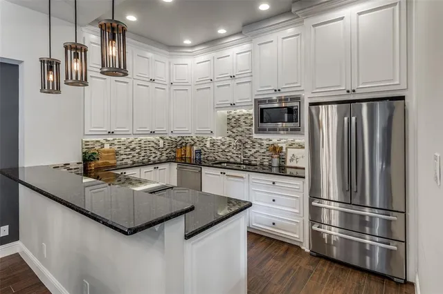 a kitchen with stainless steel appliances granite countertop a refrigerator and a stove top oven