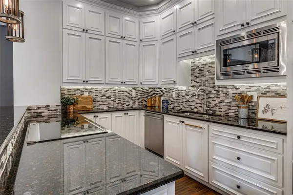 a kitchen with stainless steel appliances granite countertop a sink stove and microwave