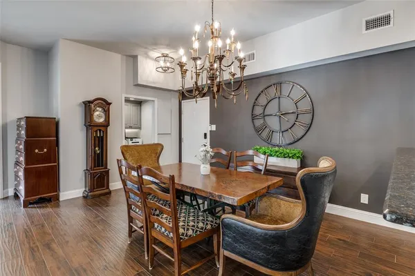 a dining room with furniture a chandelier and wooden floor