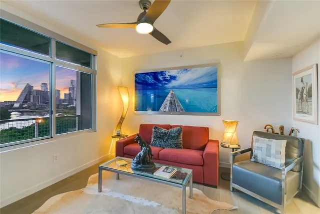a living room with stainless steel appliances furniture and a flat screen tv