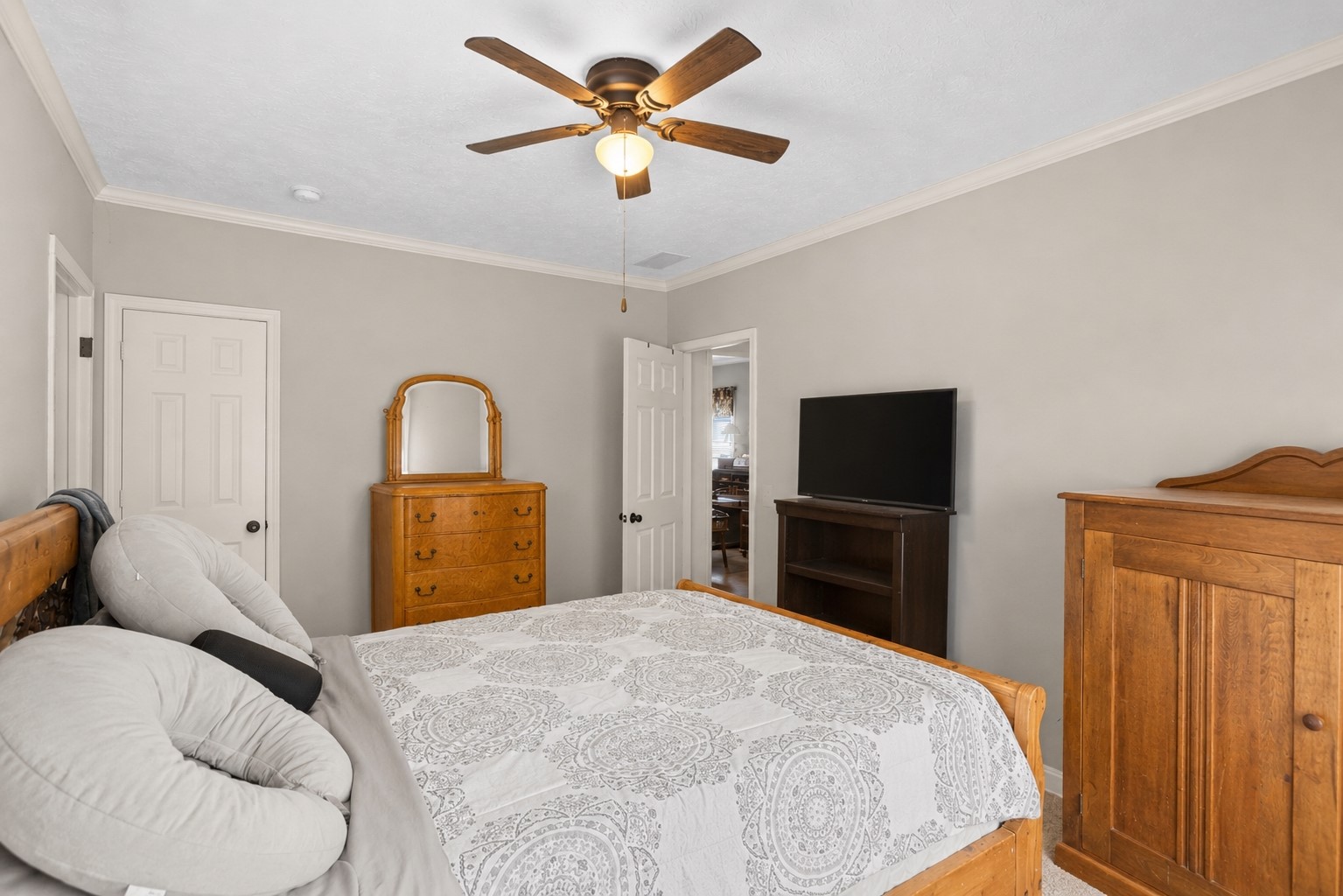 1800 2110th Road Hugo, OK 74743 - Photo 20 of 27 Neutral wall paint, crown molding, and a ceiling fan with integrated lighting