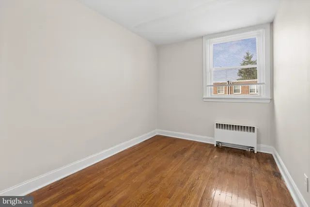 an empty room with a hardwood and a window