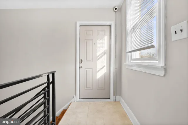 a view of a hallway with wooden floor and a window