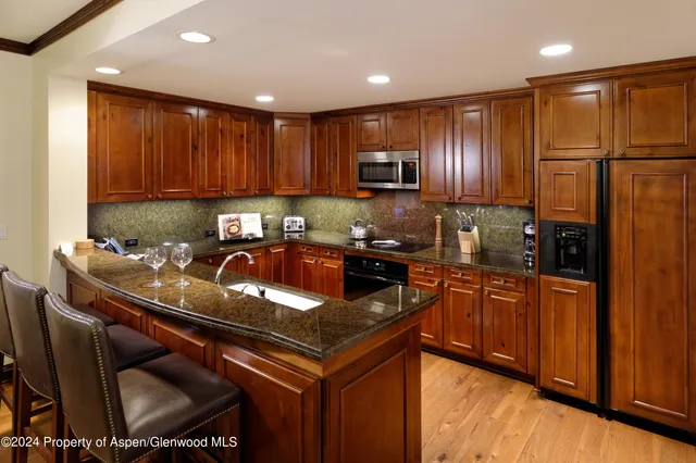 a kitchen with stainless steel appliances granite countertop a sink refrigerator and cabinets