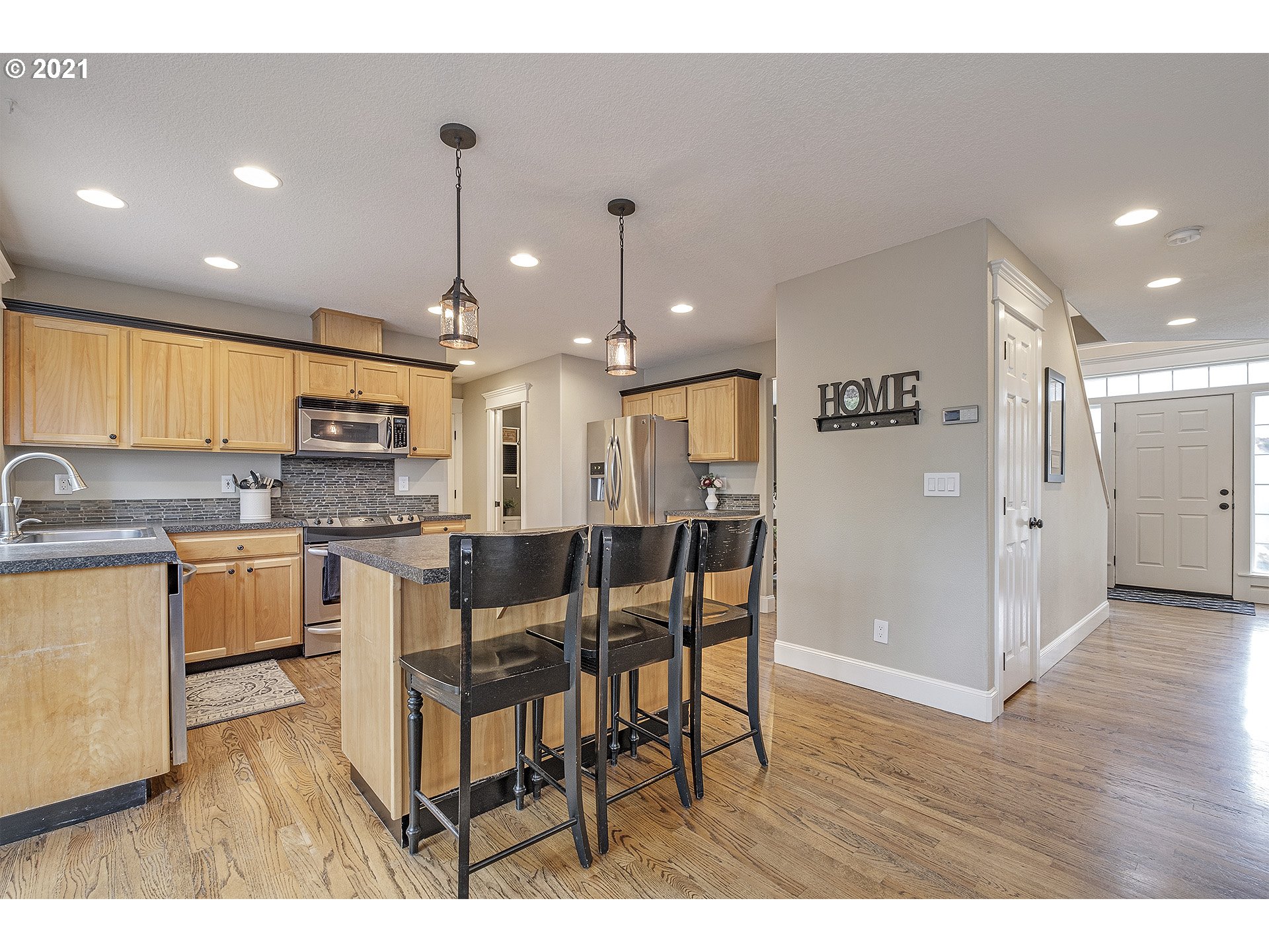 716 Roxe Drive Forest Grove, OR 97116 - Photo 11 of 32 a open kitchen with stainless steel appliances granite countertop a refrigerator a sink a stove a dining table and chairs
