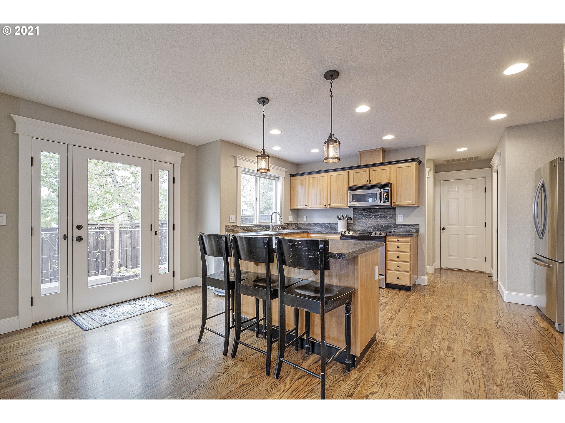 716 Roxe Drive Forest Grove, OR 97116 - Photo 12 of 32 a open kitchen with stainless steel appliances kitchen island granite countertop a table chairs and a refrigerator