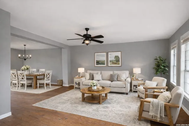 a living room with furniture and a dining table with wooden floor