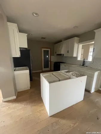 a white kitchen with wooden cabinets and white appliances