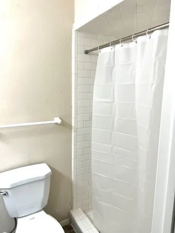 a bathroom with a toilet and shower