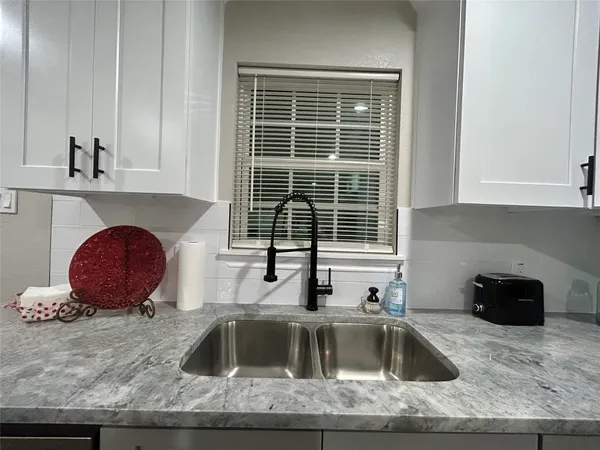 a kitchen with granite countertop a sink and a stove top oven