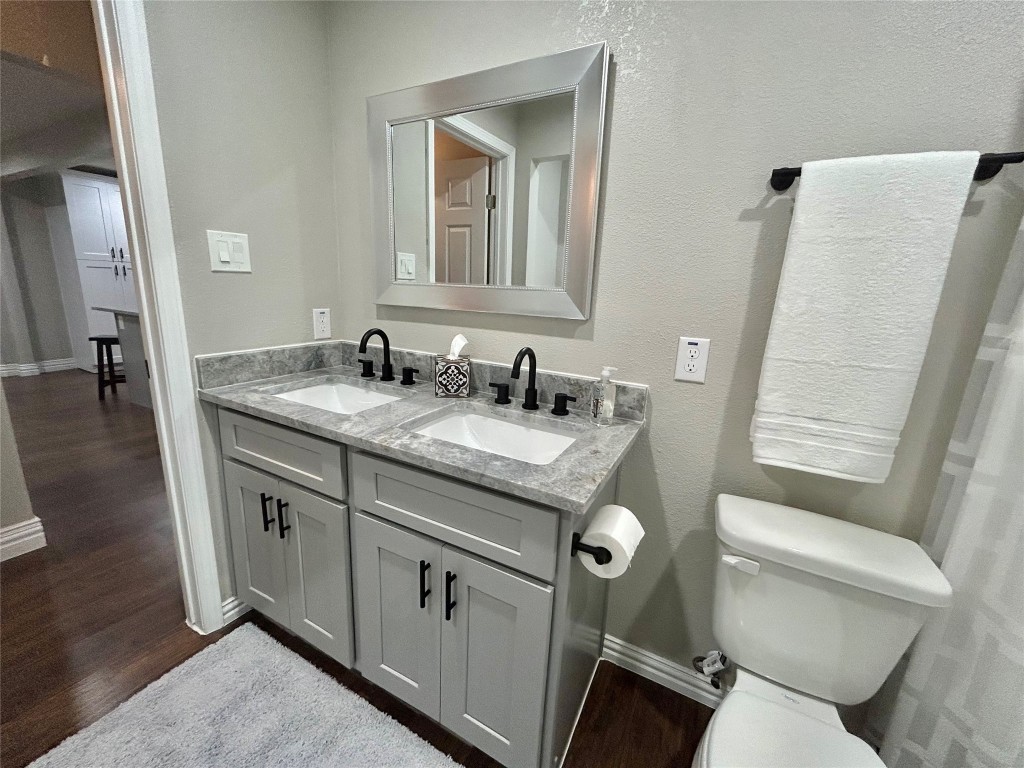 4010 Chapman Street Houston, TX 77009 - Photo 15 of 22 a bathroom with a granite countertop toilet sink and mirror