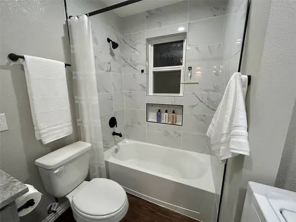 a white bath tub sitting next to a white toilet and sink