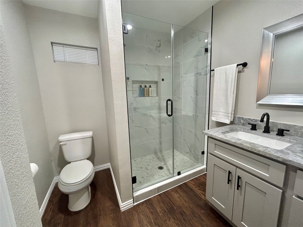 4010 Chapman Street Houston, TX 77009 - Photo 19 of 22 a bathroom with a granite countertop sink a toilet and a shower