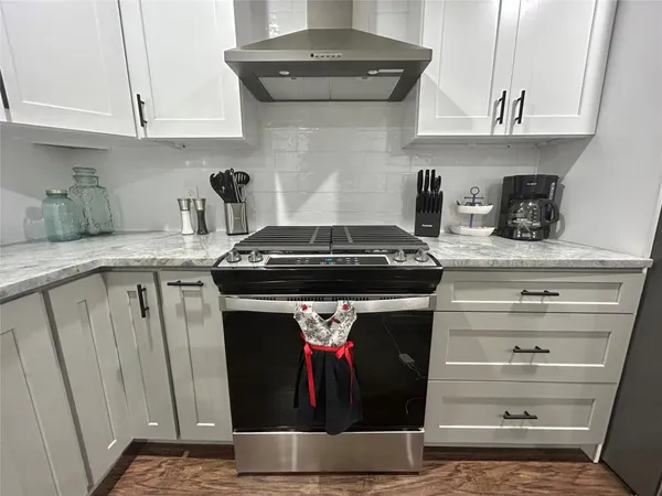 a kitchen with stainless steel appliances granite countertop a stove and a cabinets