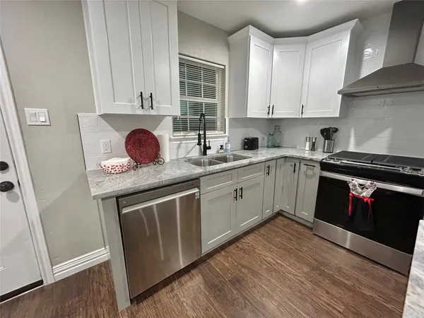 a kitchen with stainless steel appliances granite countertop a sink stove and cabinets