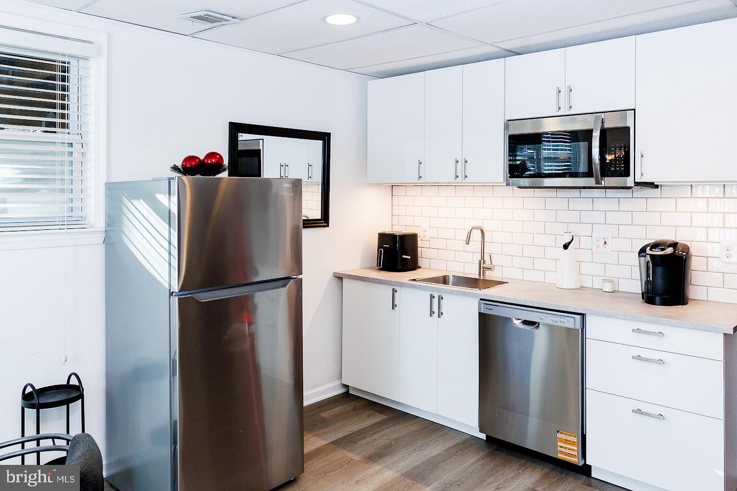 7286 Earlys Road Warrenton, VA 20187 - Photo 11 of 25 a kitchen with white cabinets and stainless steel appliances