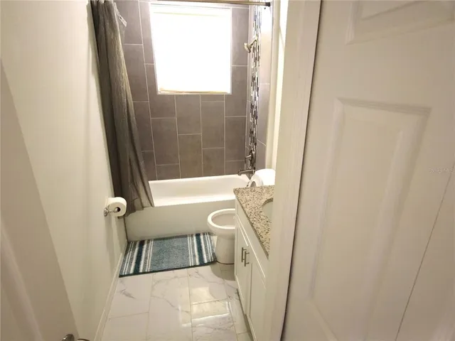 a view of a bathroom with tub and shower