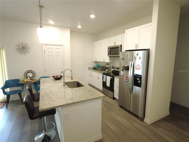 a kitchen with stainless steel appliances granite countertop a stove refrigerator sink and cabinets