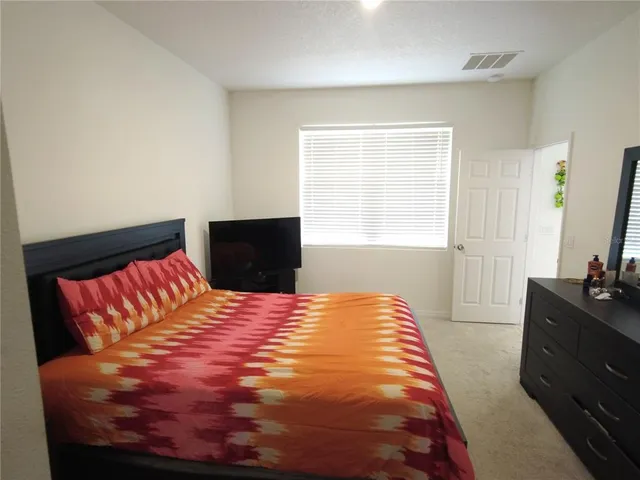 a bedroom with a bed and flat screen tv