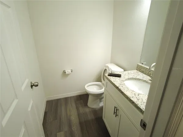 a bathroom with a granite countertop toilet and a sink
