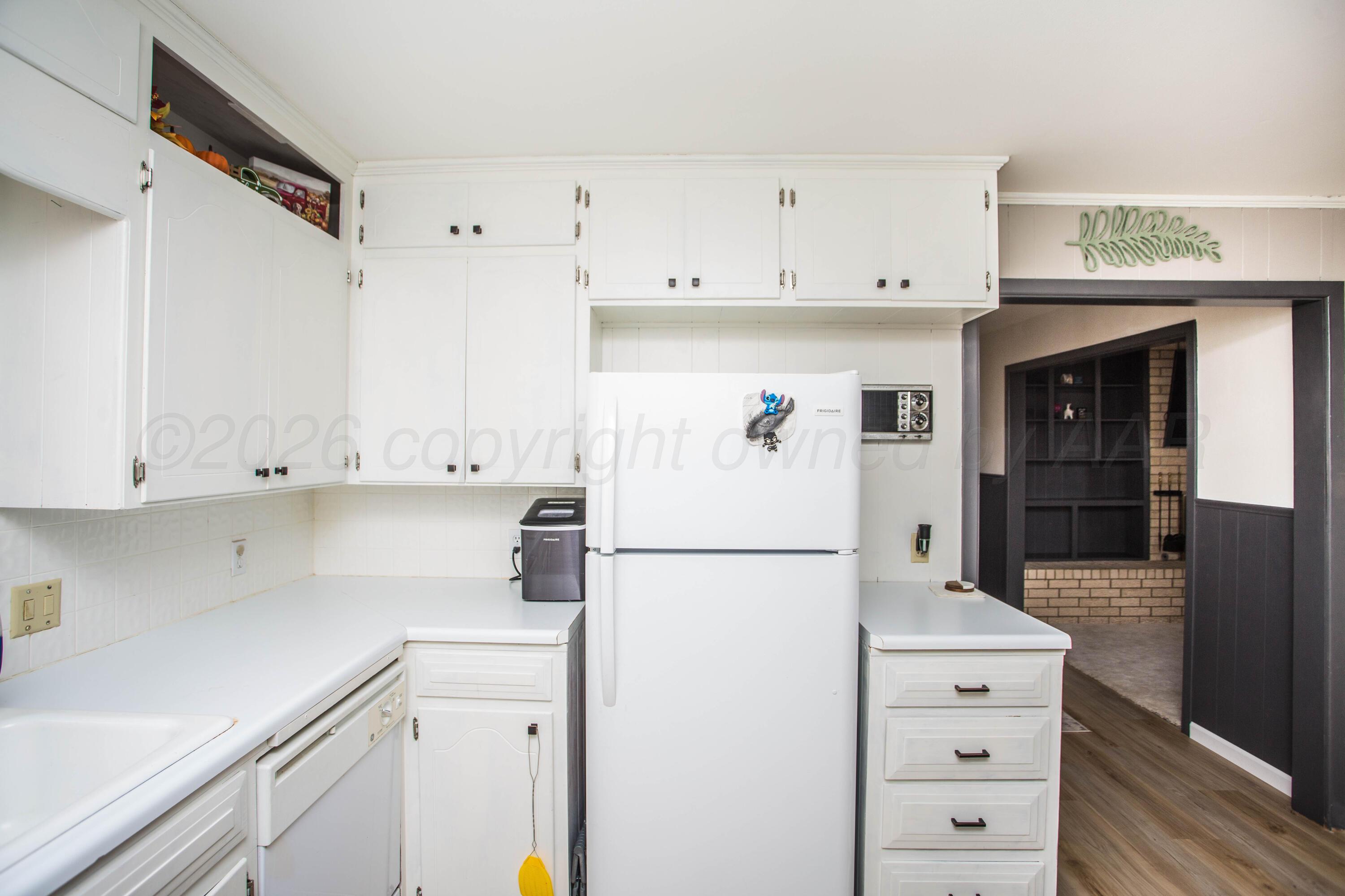 73 Houston Road Tulia, TX 79088 - Photo 19 of 55 a kitchen with refrigerator cabinets and white appliances